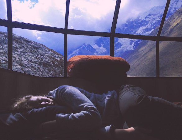 Dormire bene - Nella suggestiva immagine della fotografa Maeghan Smulders una ragazza dorme serena. Le montagne sullo sfondo la attendono per una nuova escursione giornaliera. Il Sole è già alto ed è ora di svegliarsi!