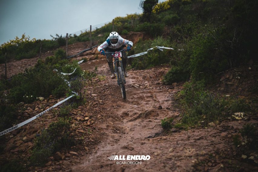 Mountain biker che mantiene postura morbida mentre la bici si muove su terreno fangoso