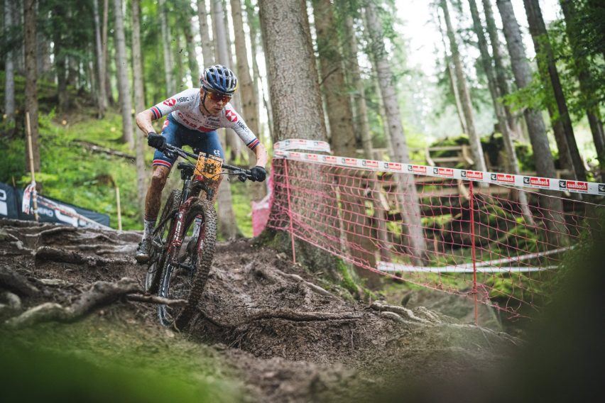 Rider MTB che osserva il trail bagnato in anticipo per leggere il terreno e scegliere la linea migliore