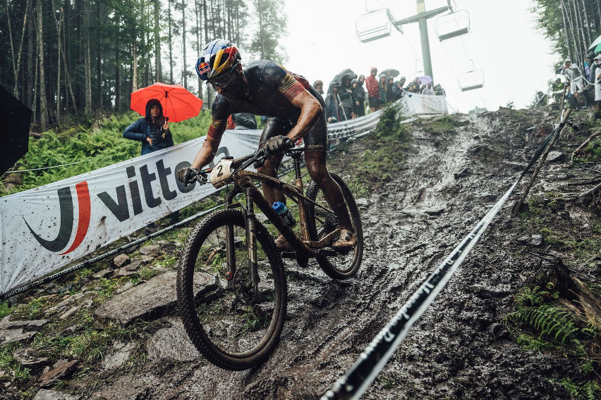 Rider che mantiene velocità costante attraversando una sezione fangosa del trail
